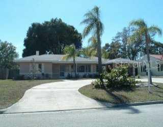 a front view of a house with a yard and tree