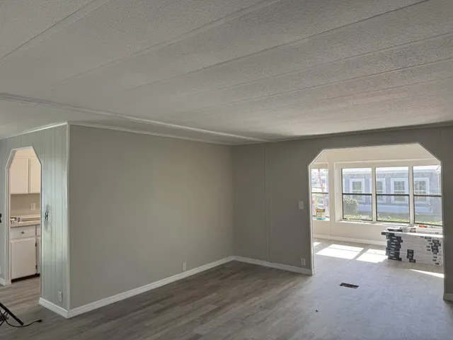 an empty room with fireplace and windows