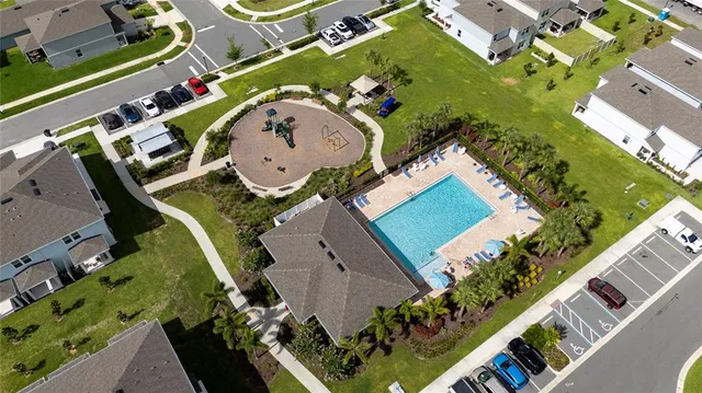 an aerial view of a house with a swimming pool a yard and a fountain