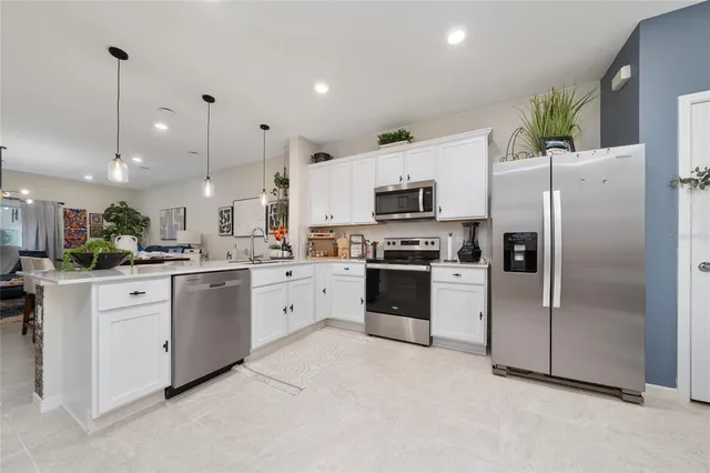 a kitchen with granite countertop white cabinets and stainless steel appliances