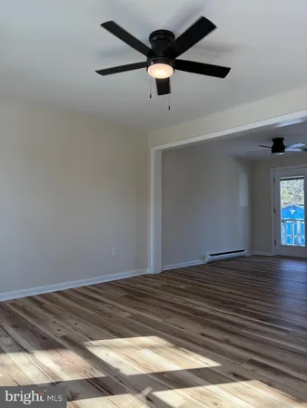 a view of empty room with wooden floor