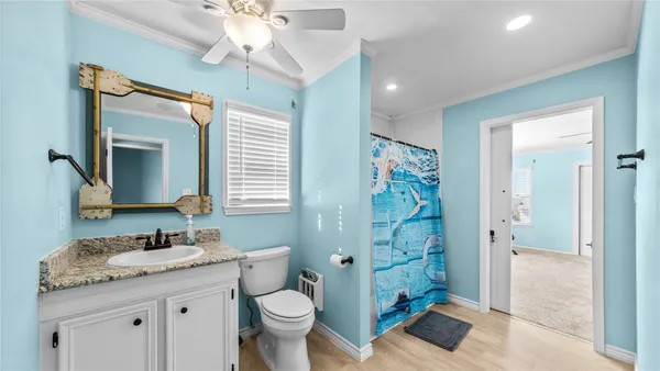 a bathroom with a granite countertop sink toilet a mirror a vanity and shower