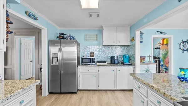 a kitchen with granite countertop a refrigerator and a sink