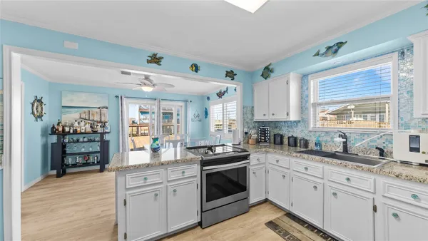 a kitchen with granite countertop a sink stainless steel appliances and cabinets