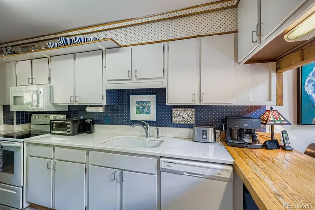 a kitchen with stainless steel appliances a sink a stove and a refrigerator