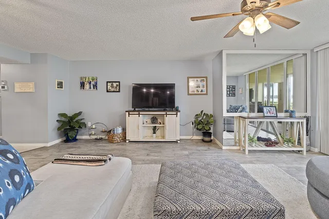 a living room with furniture a flat screen tv and a chandelier