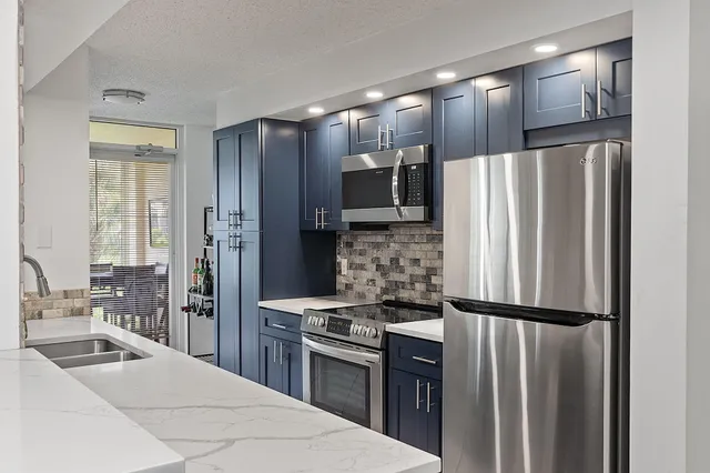 a kitchen with stainless steel appliances a refrigerator and a stove top oven