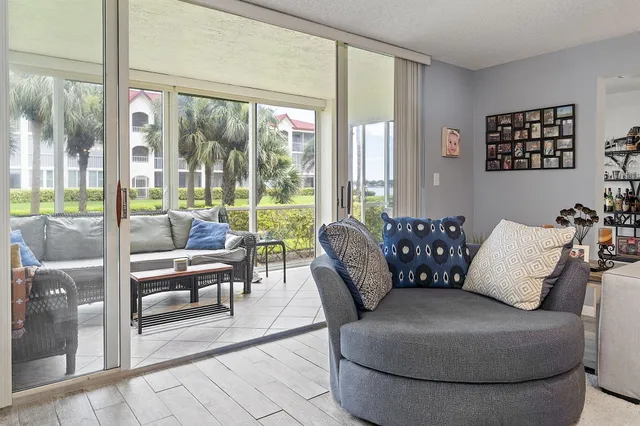a living room with furniture and a floor to ceiling window