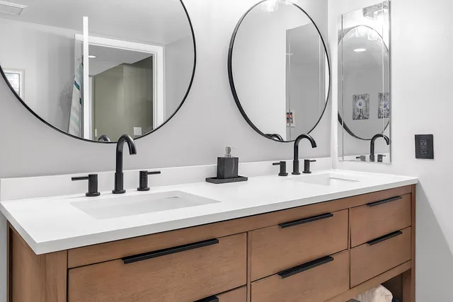 a bathroom with double vanity sinks and a mirror