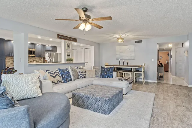 a living room with furniture and kitchen view