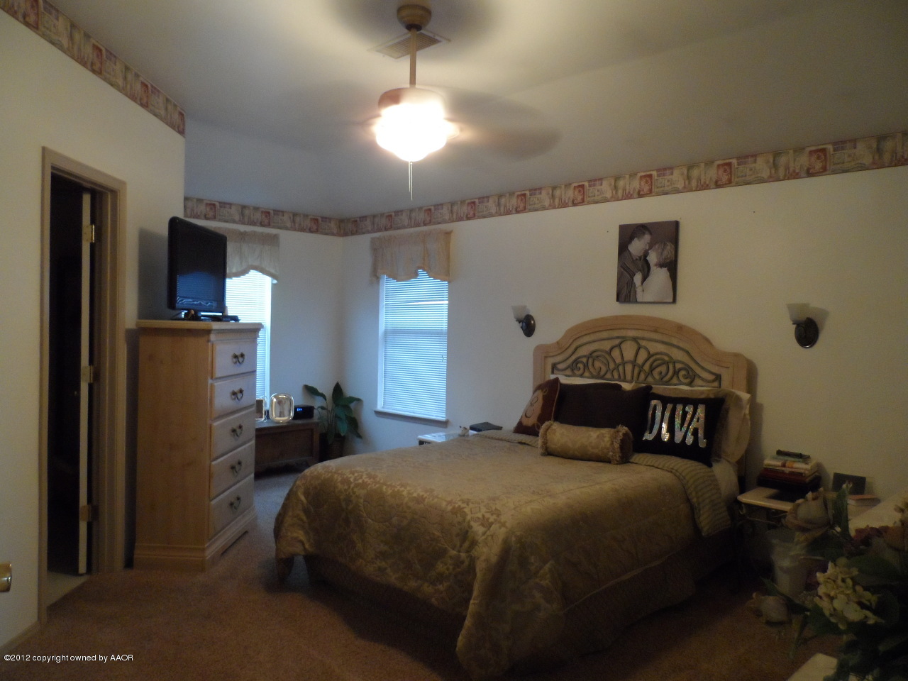 1173 Rushmore Drive Amarillo, TX 79110 - Photo 14 of 26 a bedroom with a bed and a chandelier
