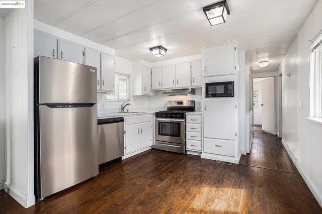 a kitchen with a refrigerator stove and white cabinets