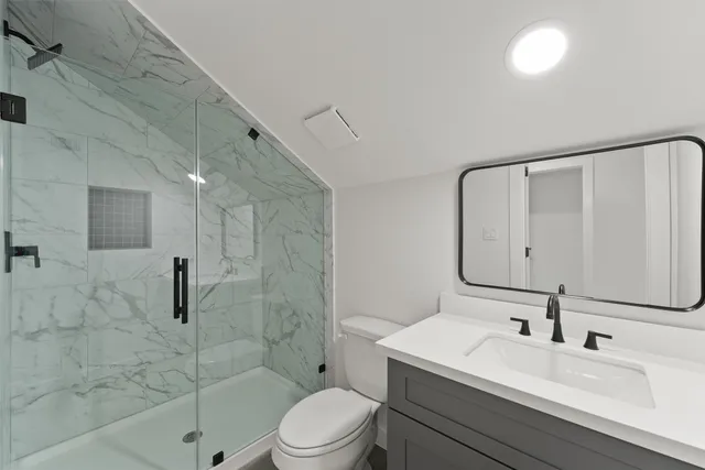 a bathroom with a sink a toilet and shower