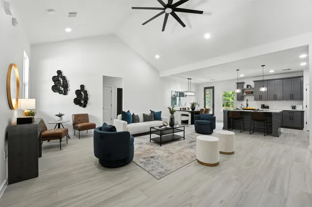 a living room with lots of furniture and kitchen view