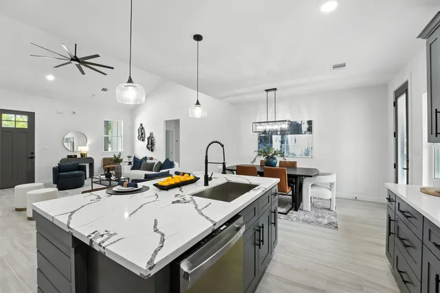 a kitchen with a sink a counter space appliances and wooden floor