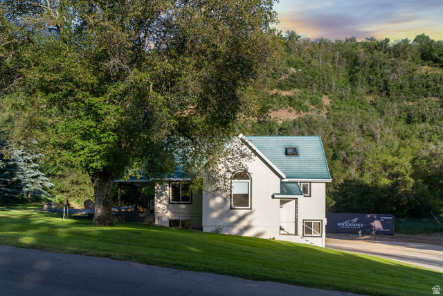 10686 South Covered Brg Cyn Road, Unit 14 Spanish Fork, UT 84660 - Photo 17 of 44 White stucco exterior with a distinctive teal shingle roof, complemented by a prominent skylight and arched window