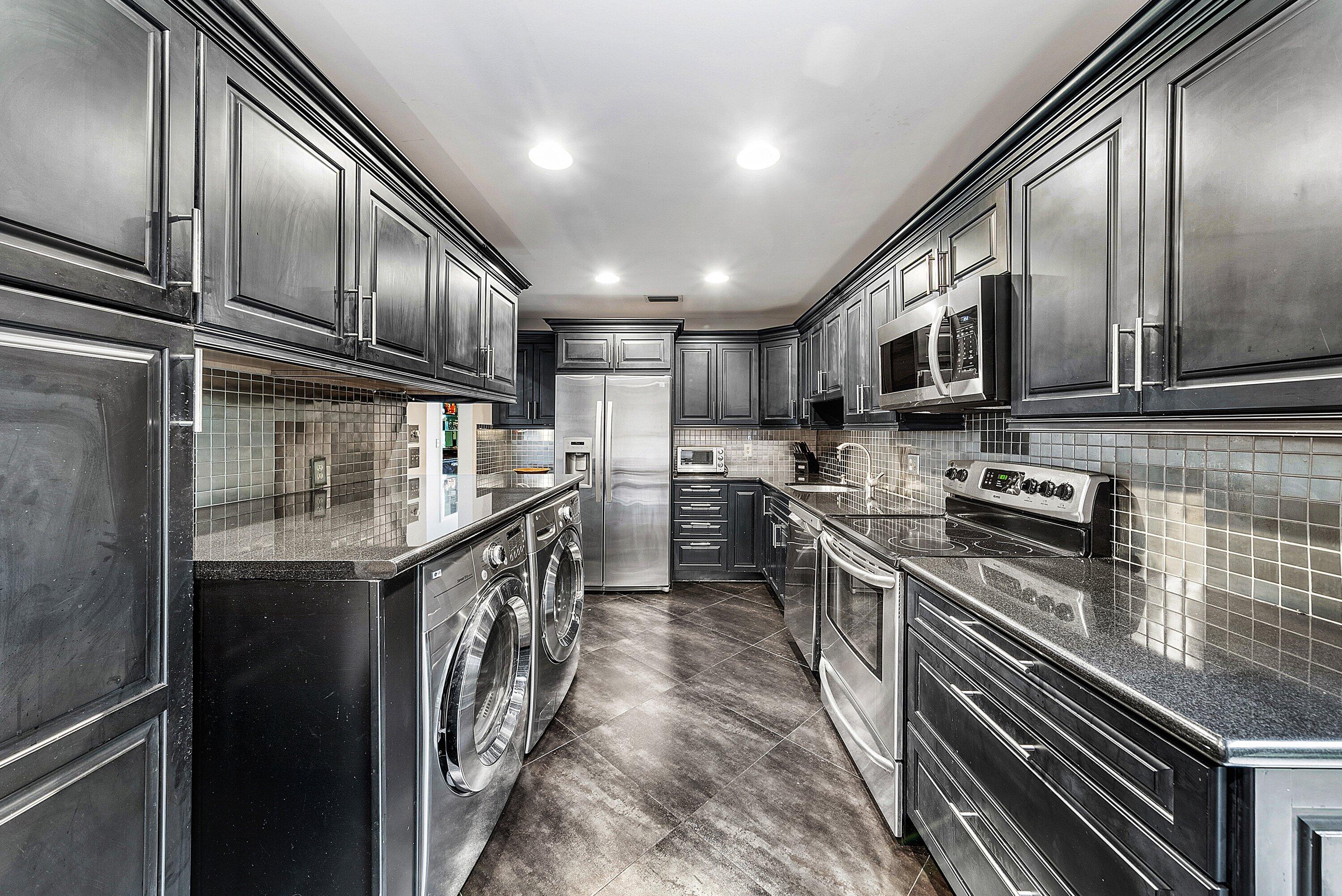 23 Eastgate Drive, Unit C Boynton Beach, FL 33436 - Photo 21 of 71 a kitchen with stainless steel appliances granite countertop a sink a stove top oven a refrigerator with grey cabinets