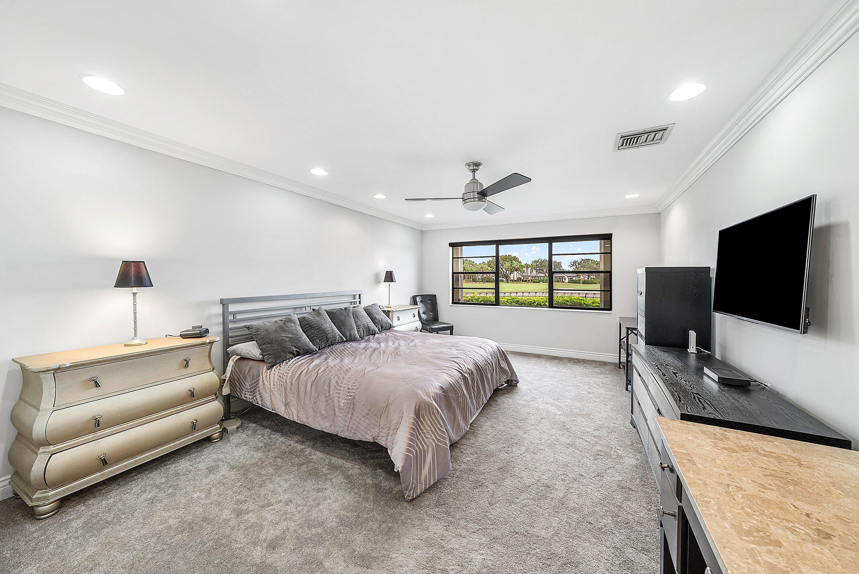 23 Eastgate Drive, Unit C Boynton Beach, FL 33436 - Photo 23 of 71 a spacious bedroom with a bed and a flat screen television