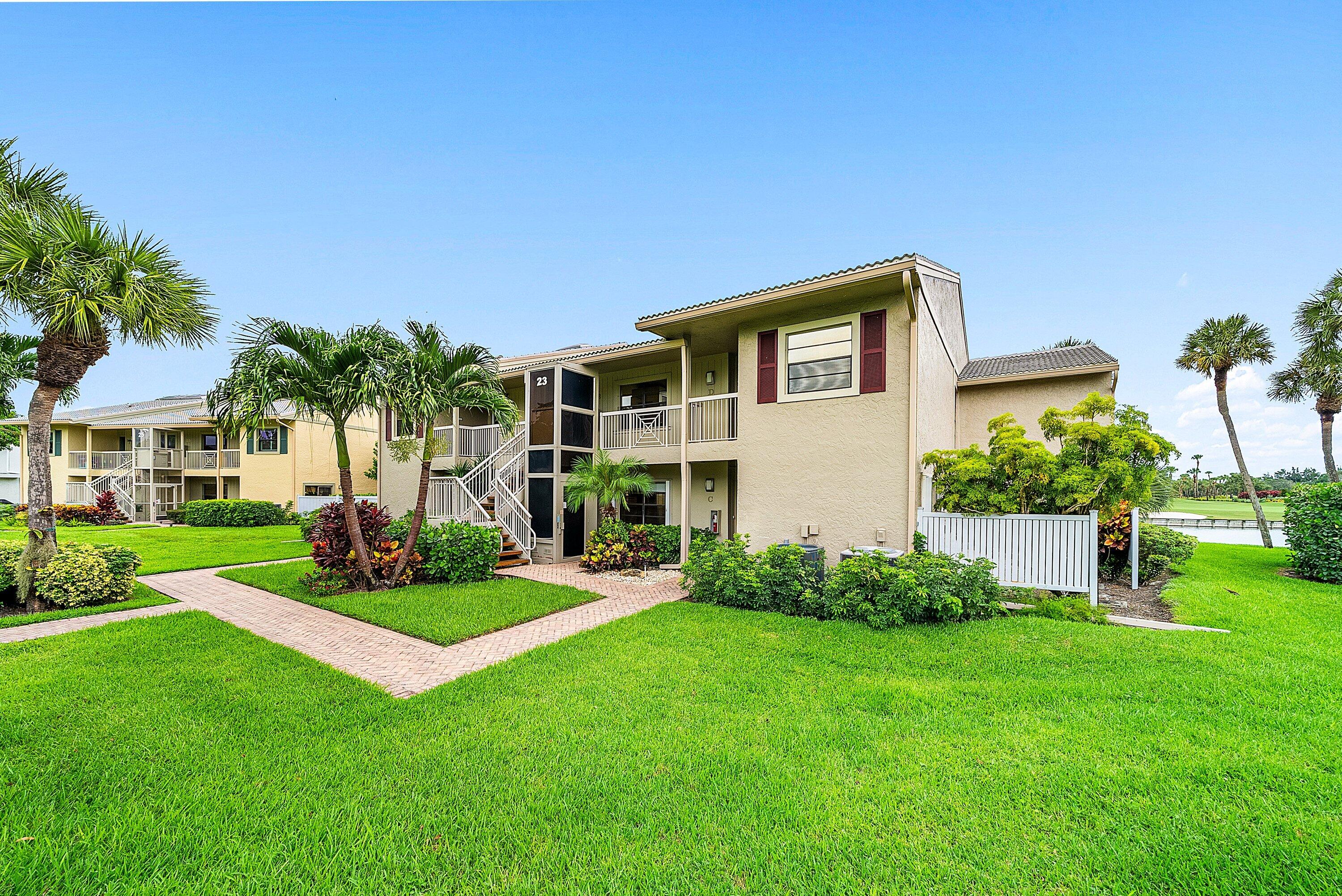 23 Eastgate Drive, Unit C Boynton Beach, FL 33436 - Photo 4 of 71 a front view of a house with a yard and trees