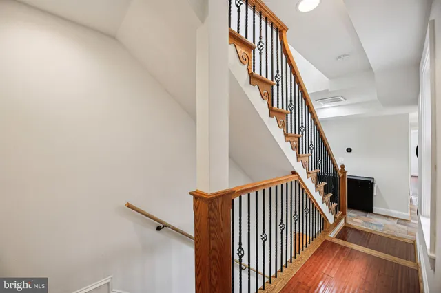 a view of staircase with wooden floor and white walls