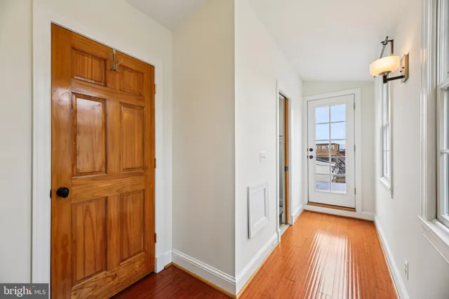a view of a hallway with wooden floor and front door
