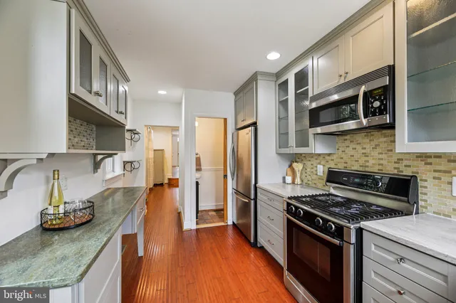 a kitchen with stainless steel appliances granite countertop a stove and a refrigerator