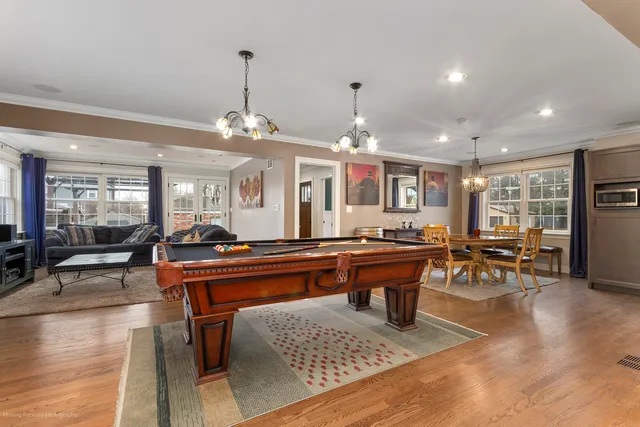 a living room with furniture a dining table and chairs with wooden floor