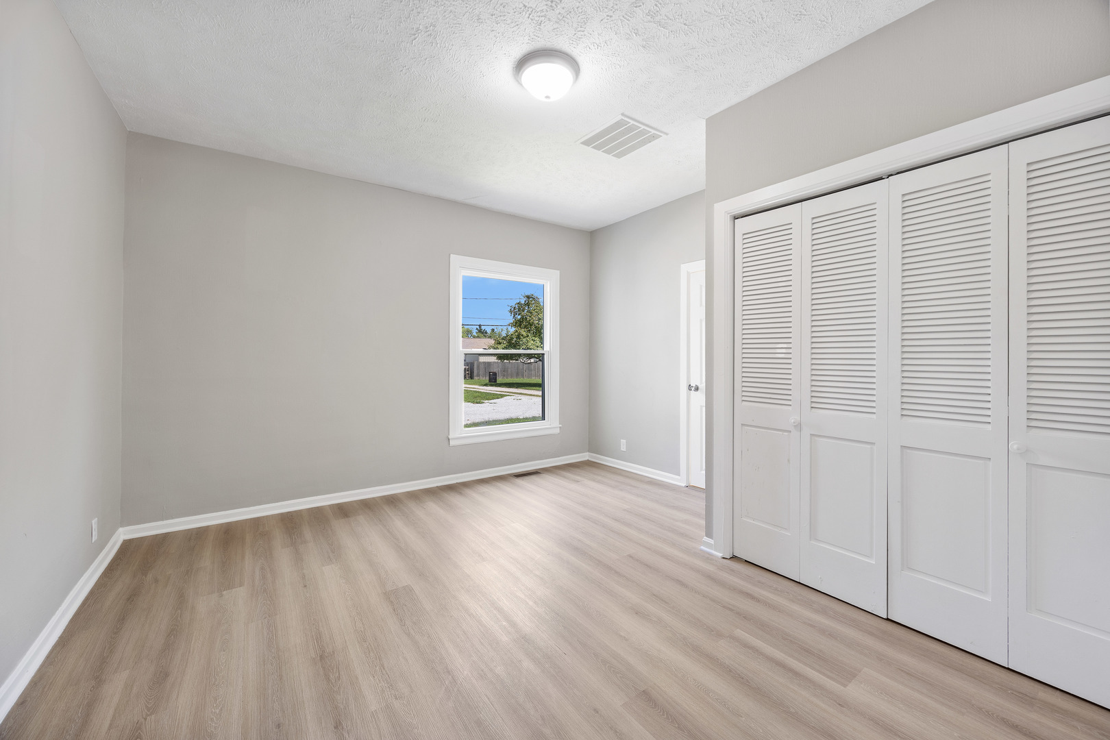 722 East Madison Avenue Chrisman, IL 61924 - Photo 14 of 23 an empty room with wooden floor and windows