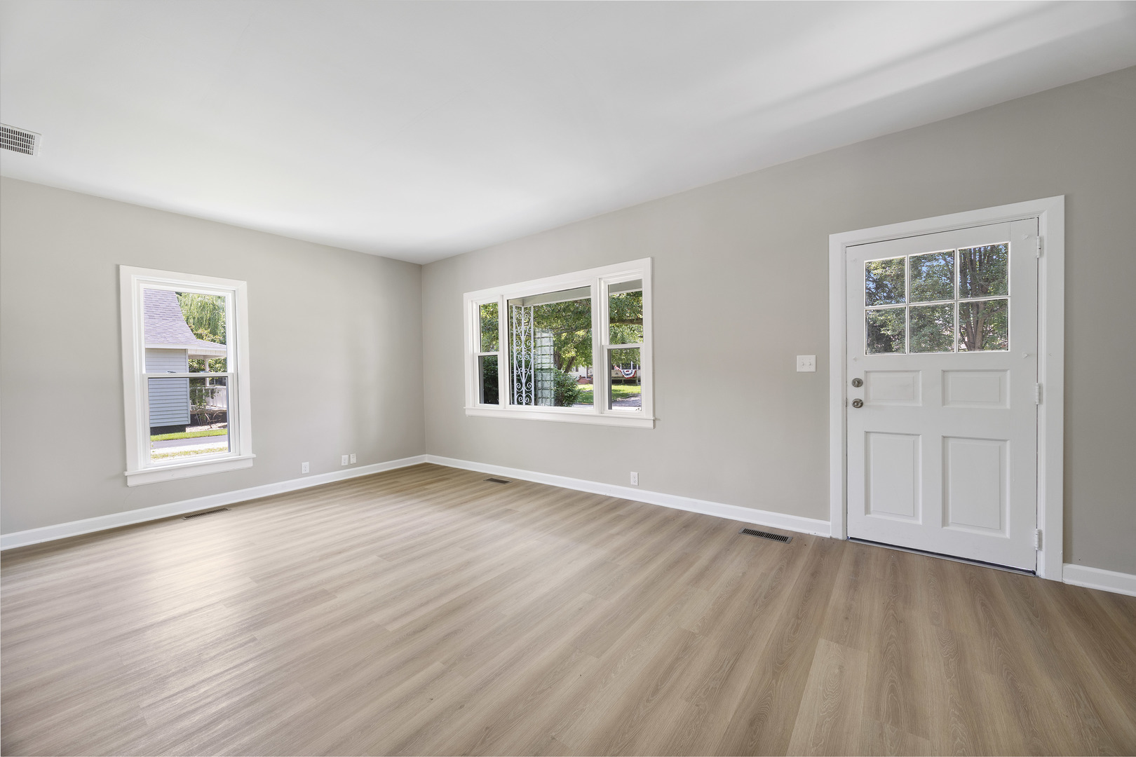 722 East Madison Avenue Chrisman, IL 61924 - Photo 4 of 23 an empty room with wooden floor and windows