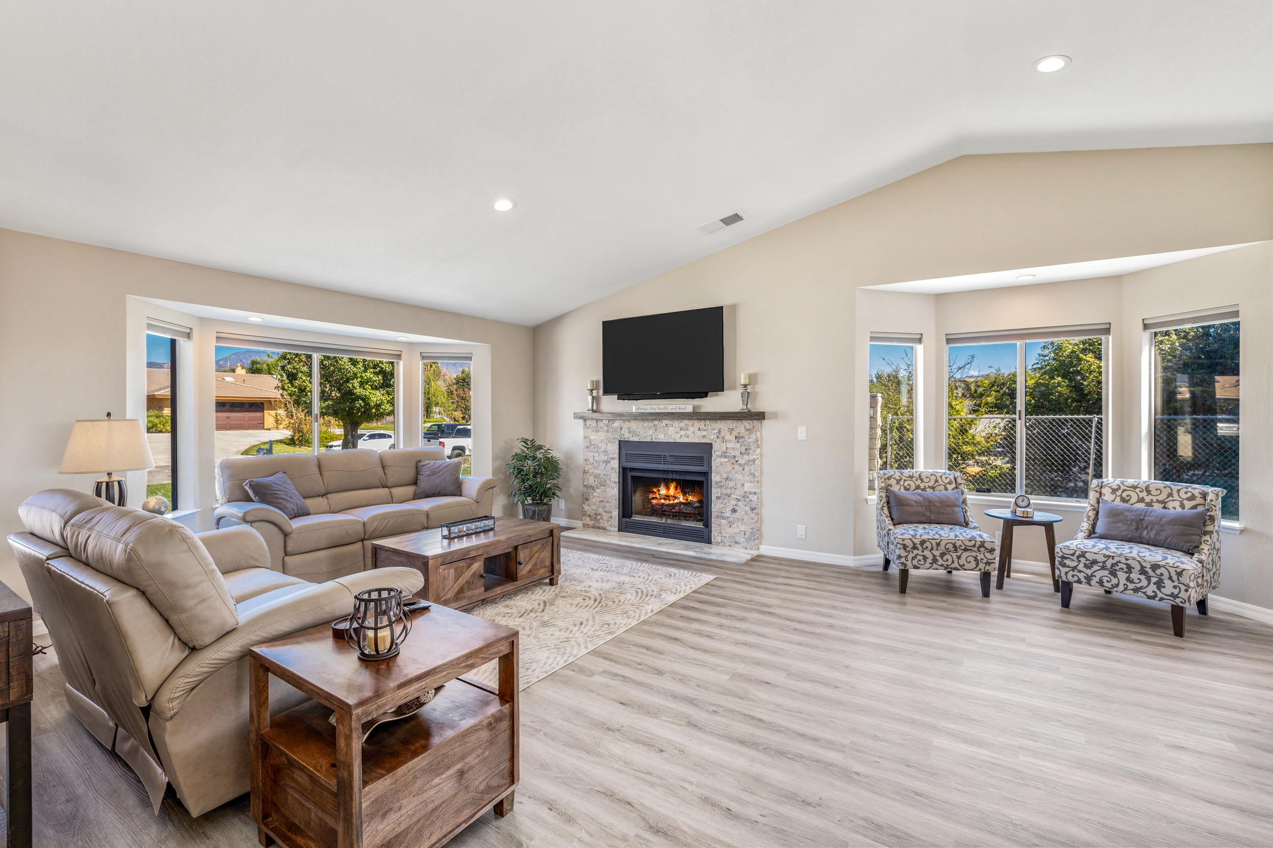 33727 Liberty Road Yucaipa, CA 92399 - Photo 3 of 39 a living room with furniture a fireplace a flat screen tv and a large window