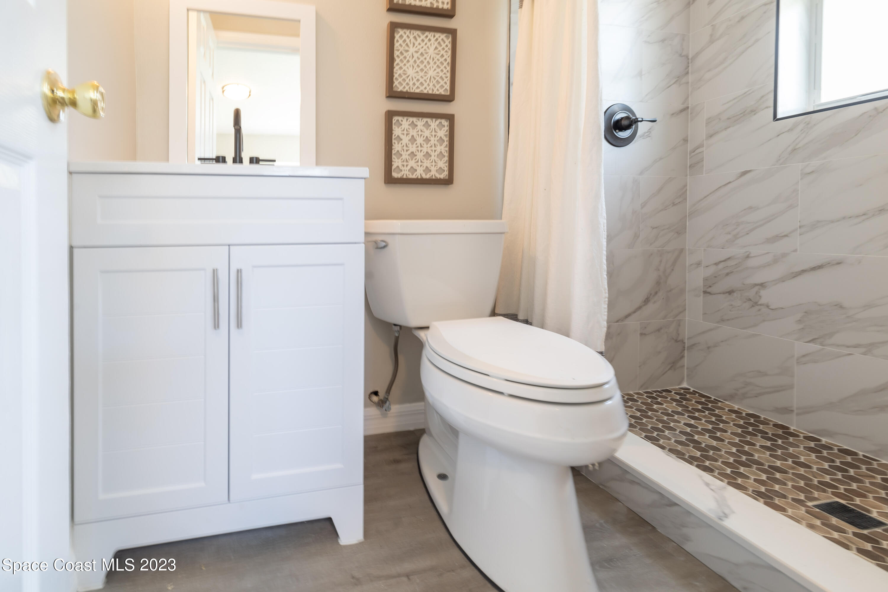 2411 Dairy Road Melbourne, FL 32901 - Photo 13 of 25 a bathroom with a toilet sink and a mirror