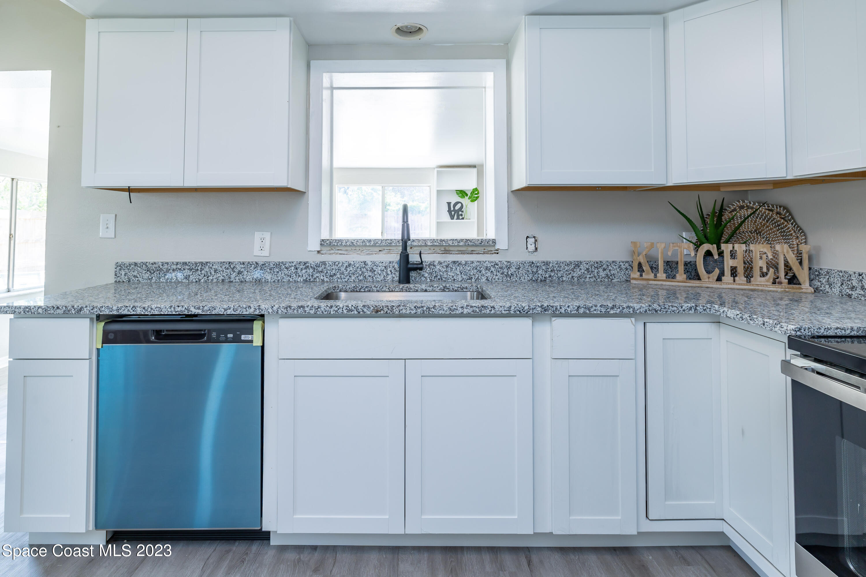 2411 Dairy Road Melbourne, FL 32901 - Photo 9 of 25 a kitchen with granite countertop white cabinets and a sink