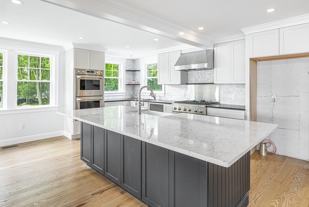 52 Elmore Road Hingham, MA 02043 - Photo 18 of 39 a large kitchen with kitchen island a large counter top and stainless steel appliances