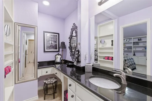 a bathroom with a granite countertop sink a mirror and shower