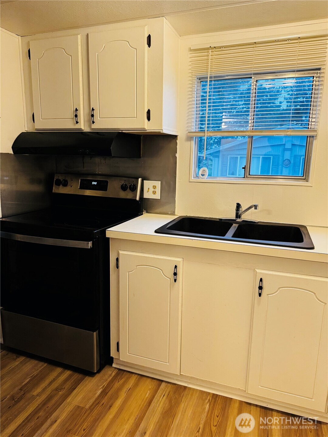 63 Onyx Street Walla Walla, WA 99362 - Photo 10 of 16 a view of kitchen with granite countertop white cabinets and black appliances