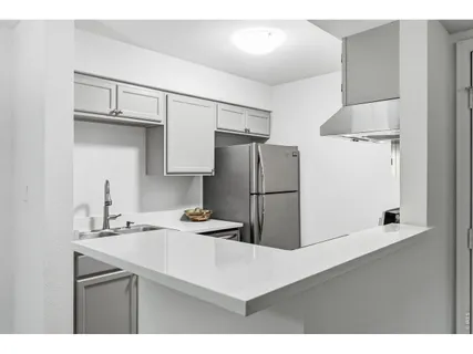 a kitchen with refrigerator cabinets and wooden floor