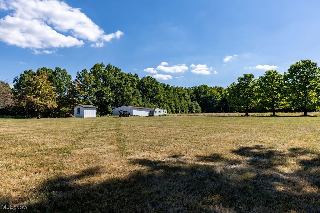 8131 Leffingwell Road Canfield, OH 44406 - Photo 15 of 37 View of grassy yard featuring an outdoor structure, a rural view, and a wooded view