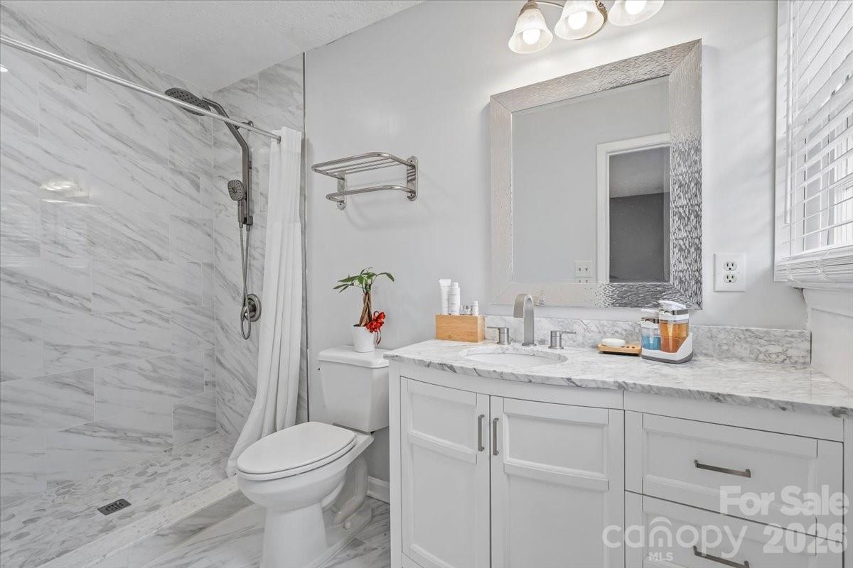 1527 Rhyne Street Shelby, NC 28152 - Photo 16 of 30 a bathroom with a granite countertop sink toilet and shower