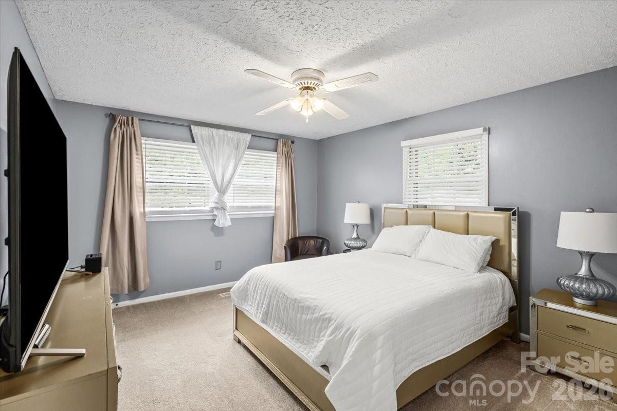 1527 Rhyne Street Shelby, NC 28152 - Photo 17 of 30 a bedroom with a large bed and a flat tv screen on dresser