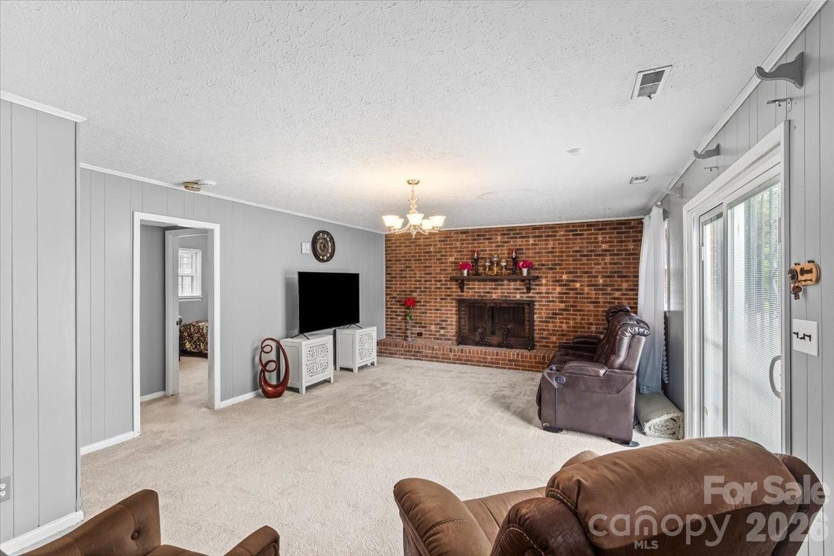 1527 Rhyne Street Shelby, NC 28152 - Photo 22 of 30 a living room with furniture a fireplace and a flat screen tv
