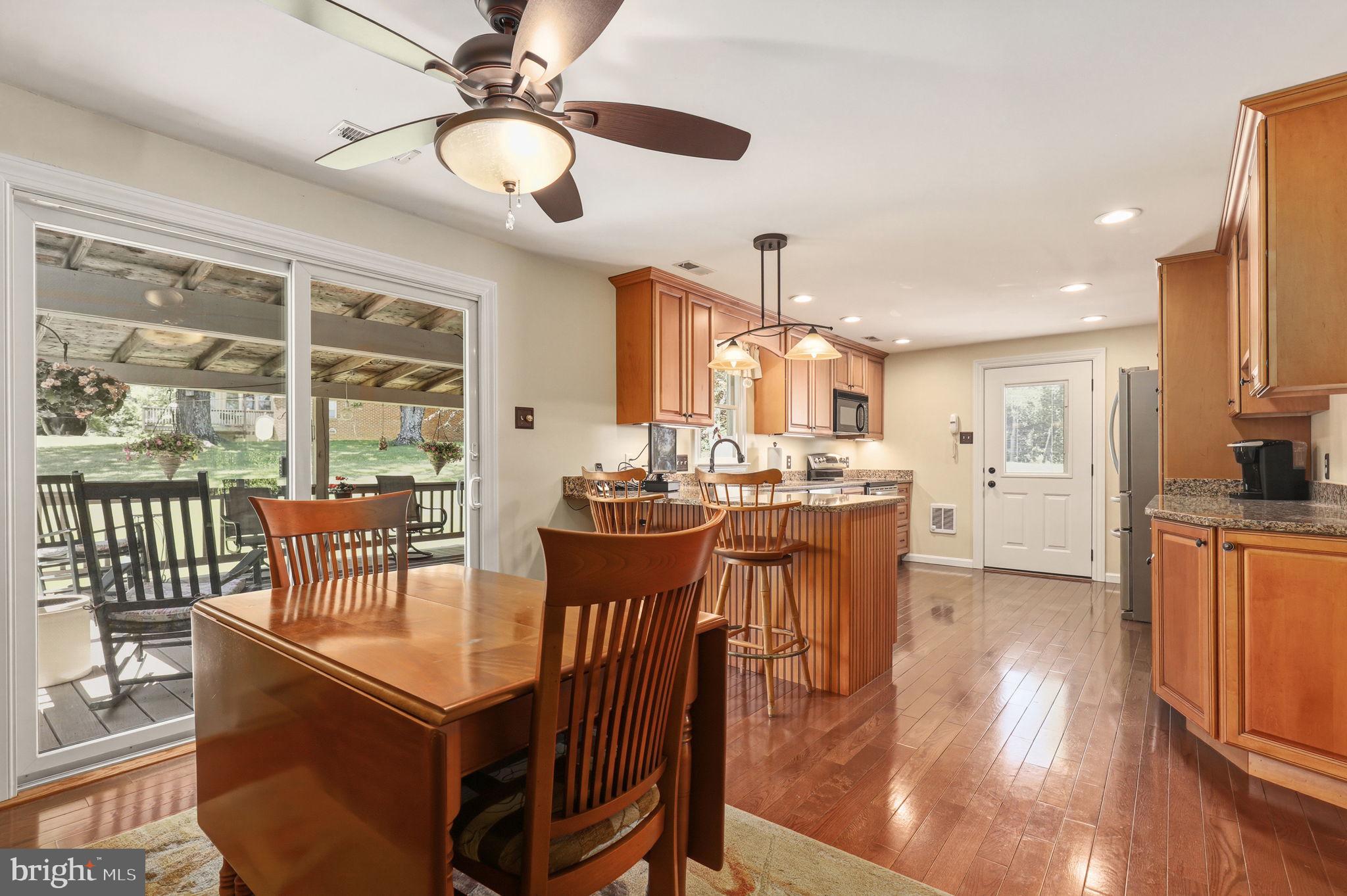 6336 Boyers Mill Road New Market, MD 21774 - Photo 7 of 49 a dining room with stainless steel appliances kitchen island granite countertop a table chairs and a chandelier