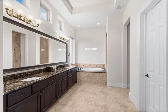 a bathroom with a granite countertop sink and a large mirror