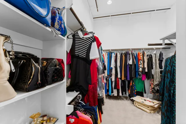 a view of walk in closet with clothes and shoes