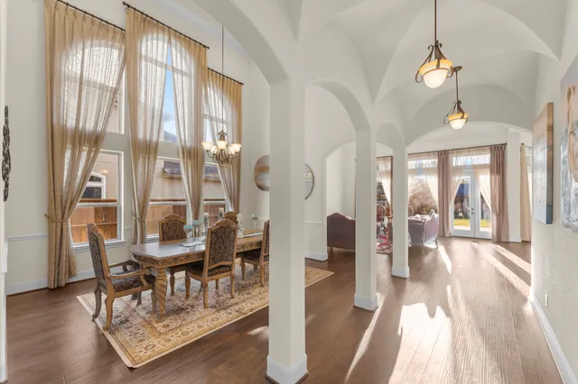 a dining room with wooden floor and a chandelier