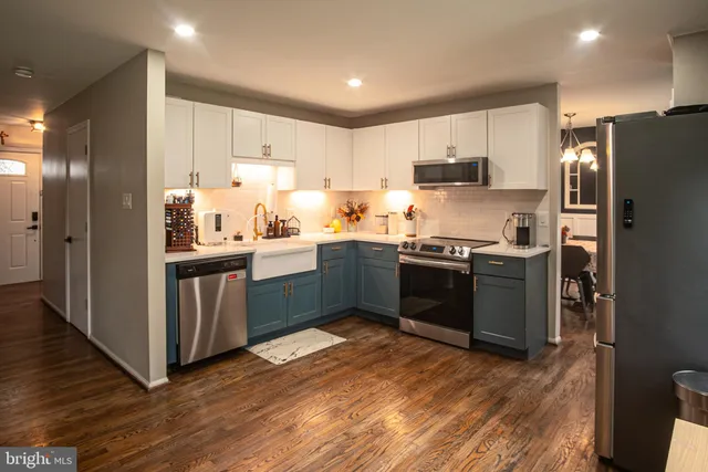 a kitchen with stainless steel appliances a sink a stove a refrigerator and cabinets