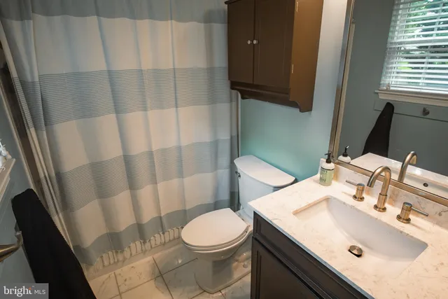 a bathroom with a sink a toilet and shower curtain