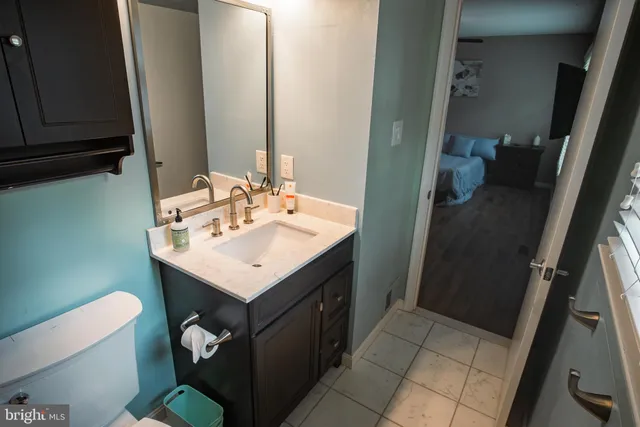 a bathroom with a sink a toilet and a mirror