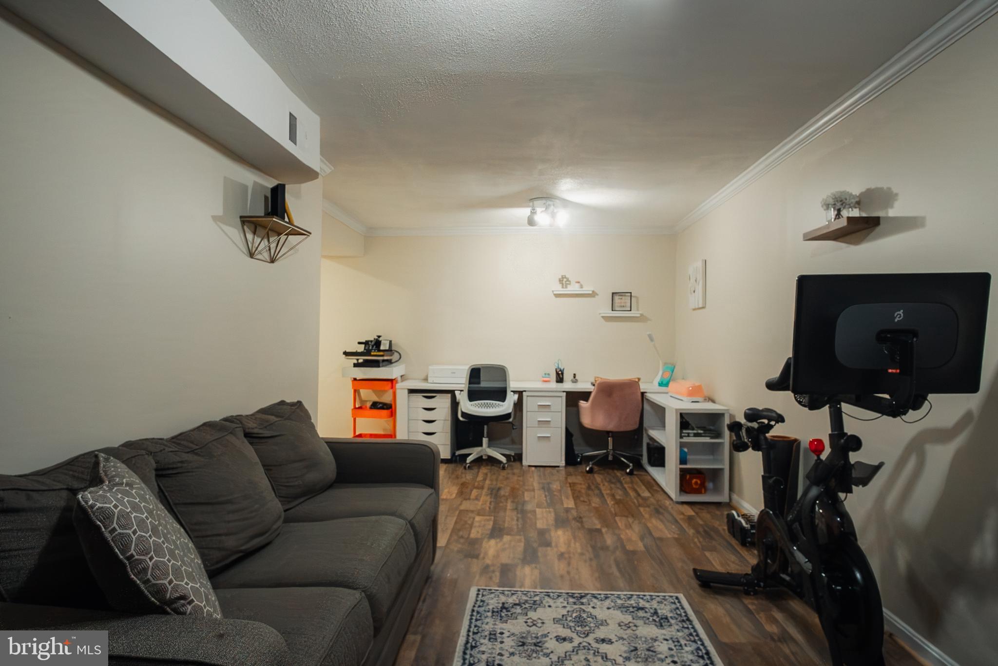 6621 Gooseander Court Frederick, MD 21703 - Photo 36 of 42 a living room with furniture and a flat screen tv