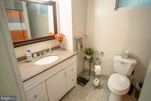 a bathroom with a granite countertop toilet sink and mirror