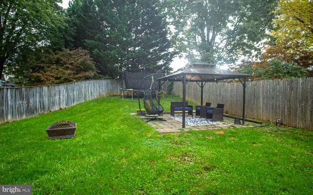 a view of backyard with table and chairs and wooden fence